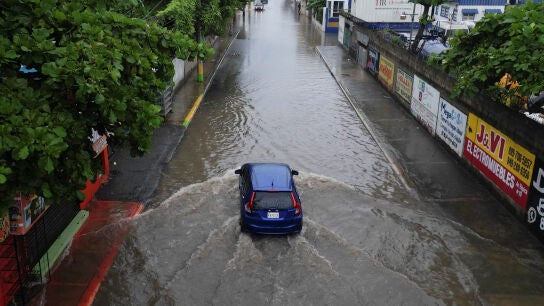 Un coche circula por las calles inundadas en Santo Domingo, Rep&uacute;blica Dominicana. Viernes 24 de octubre de 2025. 