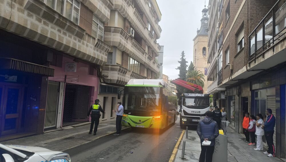 El autobús junto al camión de descarga con la grúa