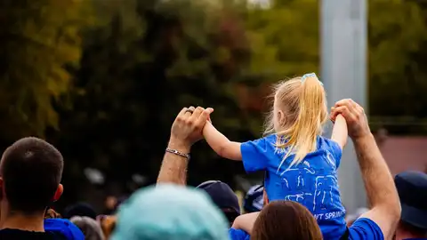 Una niña a hombros de un familiar. Una niña a hombros de un familiar.