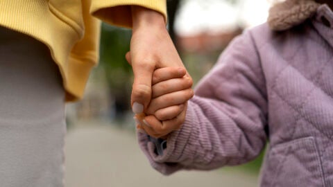 Una mujer y una niña estrechando sus manos. Una mujer y una niña estrechando sus manos.