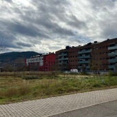 Imatge d'un solar en un poble de muntanya amb edificis de pisos al costat