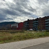 Imatge d'un solar en un poble de muntanya amb edificis de pisos al costat Imatge d'un solar en un poble de muntanya amb edificis de pisos al costat