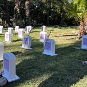 Lápidas simuladas en el Hort del Xocolater de Elche en la celebración del 25N de 2025.