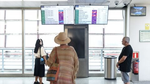 Foto de archivo: Varias personas observan los paneles de llegadas en la estaci&oacute;n de Atocha