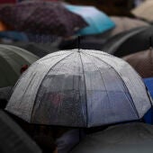 Varias personas protegiéndose de la lluvia bajo los paraguas