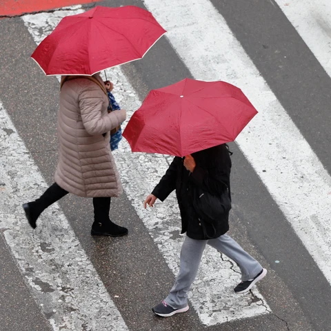 Varias personas se protegen de la lluvia en un día de lluvia en València.