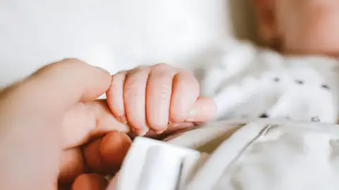 Una madre sostiene la mano de su hijo recién nacido Una madre sostiene la mano de su hijo recién nacido