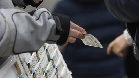 Una persona compra un décimo de la Lotería de Navidad a un vendedor ambulante en Madrid. Una persona compra un décimo de la Lotería de Navidad a un vendedor ambulante en Madrid.