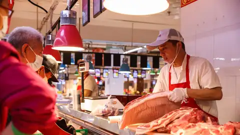 Un empleado trabaja en un puesto de venta de cerdo en un supermercado de Pekín, China Un empleado trabaja en un puesto de venta de cerdo en un supermercado de Pekín, China