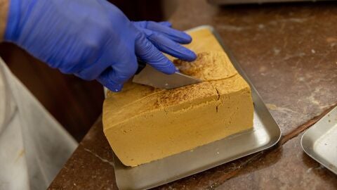 Una pastelera corta un bloque de turr&oacute;n