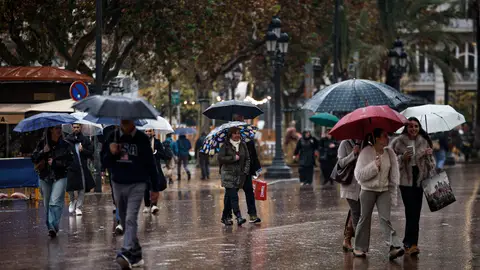 Imagen de archivo de varias personas paseando bajo la lluvia Imagen de archivo de varias personas paseando bajo la lluvia