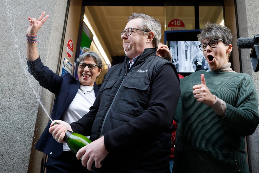 Varias personas celebran a las puertas de la administración de loterías del número 10 de la calle Barquillo, en Madrid, Varias personas celebran a las puertas de la administración de loterías del número 10 de la calle Barquillo, en Madrid,