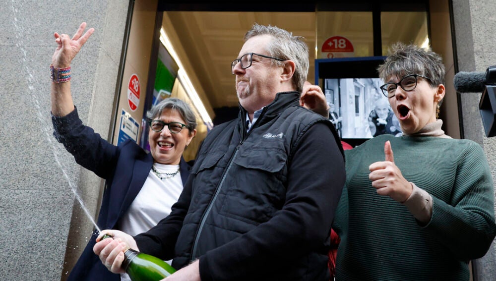 Varias personas celebran a las puertas de la administración de loterías del número 10 de la calle Barquillo, en Madrid/ EFE/Mariscal