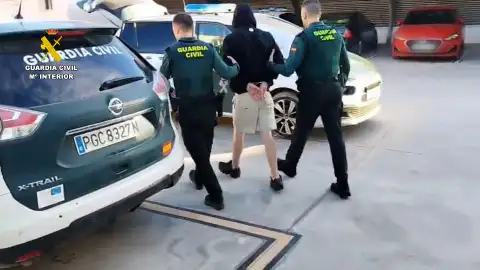 Agentes de la Guardia Civil con uno de los detenidos en Elche. Agentes de la Guardia Civil con uno de los detenidos en Elche.