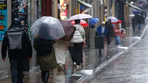 Varias personas se protegen de la lluvia en el centro de Barcelona, este sábado. Varias personas se protegen de la lluvia en el centro de Barcelona, este sábado.