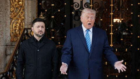 Ukrainian President Volodymyr Zelenskiy stands next to U.S. President Donald Trump
