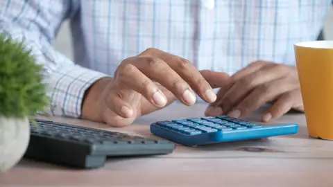 Imagen de archivo de una persona que utiliza una calculadora. Imagen de archivo de una persona que utiliza una calculadora.