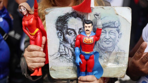 Personas sostienen figuras del presidente de Venezuela, Nicol&aacute;s Maduro, y de su esposa Cilia Flores/ EFE/ Miguel Guti&eacute;rrez