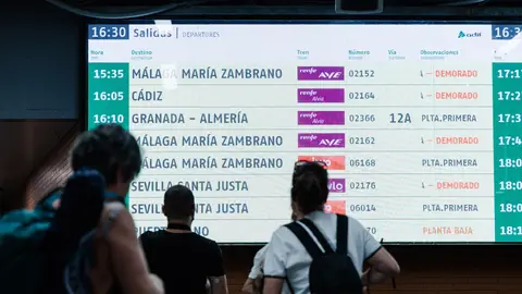 Imagen de archivo de viajeros que miran la pantalla con los destinos de los trenes. Imagen de archivo de viajeros que miran la pantalla con los destinos de los trenes.