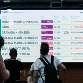 Imagen de archivo de viajeros que miran la pantalla con los destinos de los trenes. Imagen de archivo de viajeros que miran la pantalla con los destinos de los trenes.