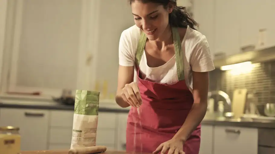 Imagen de archivo de una mujer cocinando con un delantal Imagen de archivo de una mujer cocinando con un delantal
