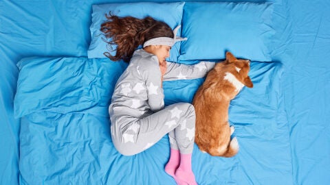 Una chica con su perro en la misma cama Una chica con su perro en la misma cama
