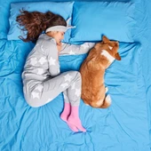 Una chica con su perro en la misma cama Una chica con su perro en la misma cama