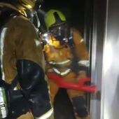 Efectivos de bomberos en el interior del hostal de El Altet de Elche durante el incendio.