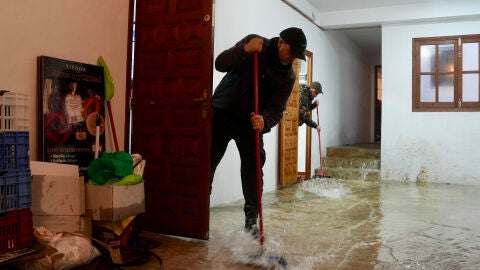 Vecinos de Grazalema (C&aacute;diz) intentan achicar agua de sus casa y locales debido a las intensas lluvias.