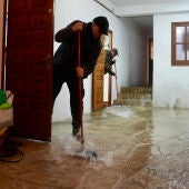 Vecinos de Grazalema (Cádiz) intentan achicar agua de sus casa y locales debido a las intensas lluvias.