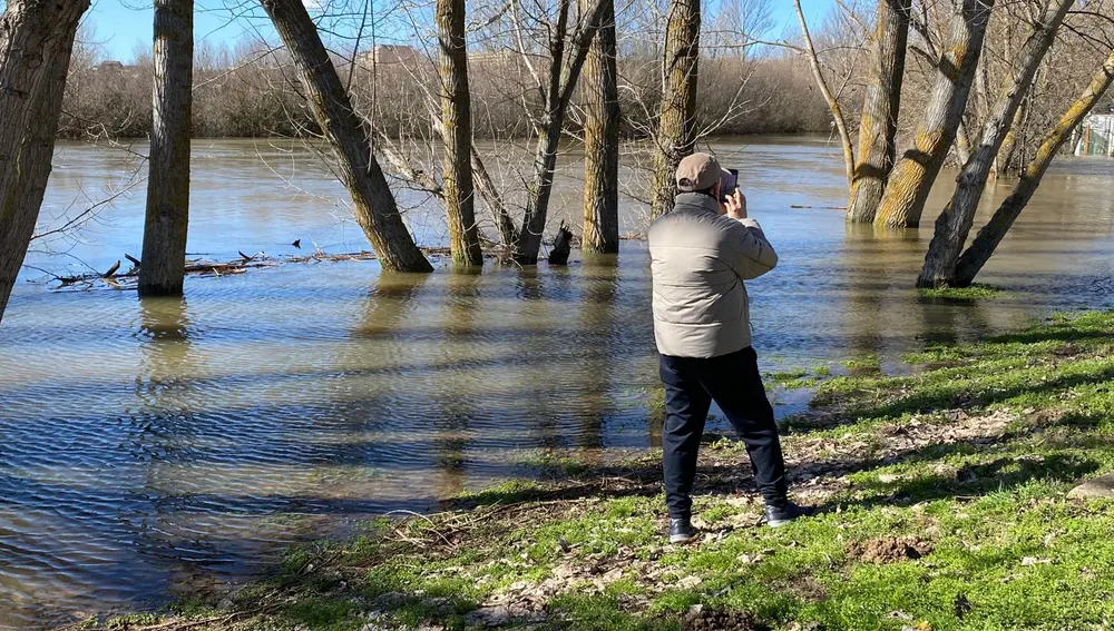 Un transeúnte toma una foto en la ribera Un transeúnte toma una foto en la ribera