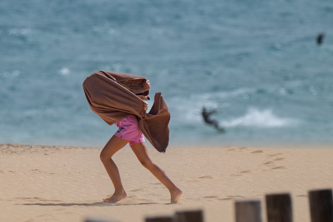 Una mujer se protege del viento este sábado en la localidad de Corralejo, municipio de La Oliva Una mujer se protege del viento este sábado en la localidad de Corralejo, municipio de La Oliva
