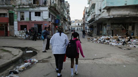 Una abuela acompa&ntilde;a a su nieta al colegio en La Habana, Cuba. 