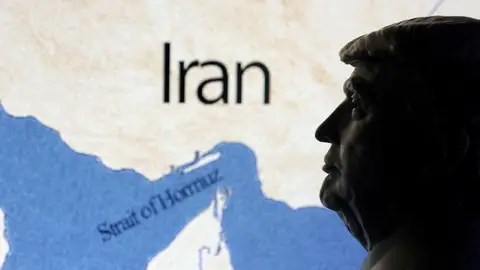 Un mapa del Estrecho de Ormuz junto a una estatua de Donald Trump. Un mapa del Estrecho de Ormuz junto a una estatua de Donald Trump.