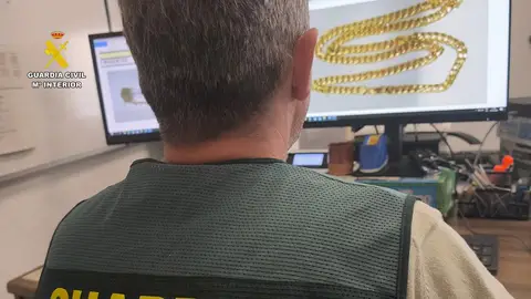 Un agente examina una de las joyas robadas Un agente examina una de las joyas robadas