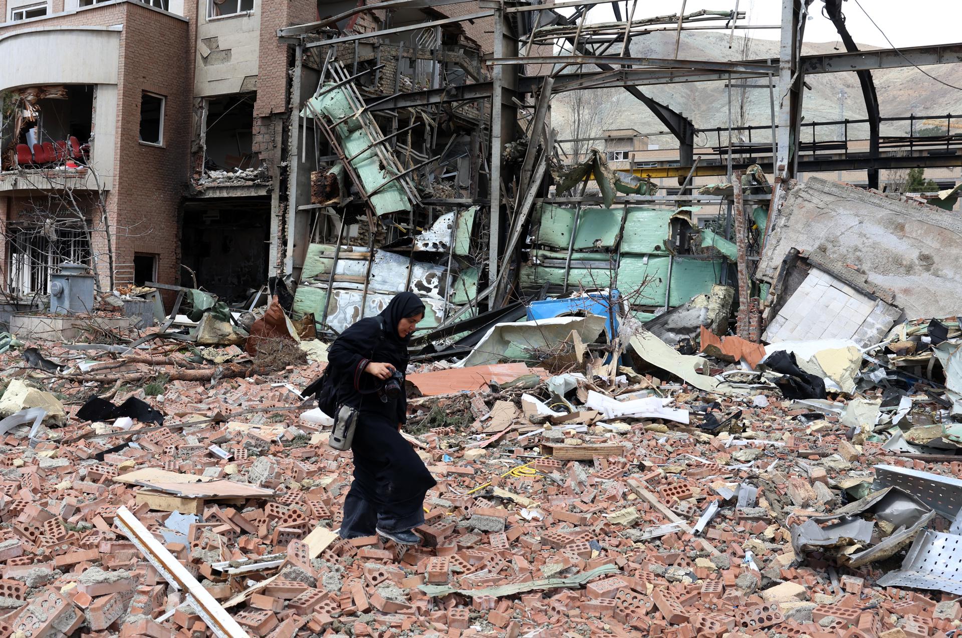 Una mujer camino entre escombros tras un ataque estadounidense en Teherán. Una mujer camino entre escombros tras un ataque estadounidense en Teherán.