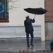 Una persona se protege de la lluvia con su paraguas. - Una persona se protege de la lluvia con su paraguas. -