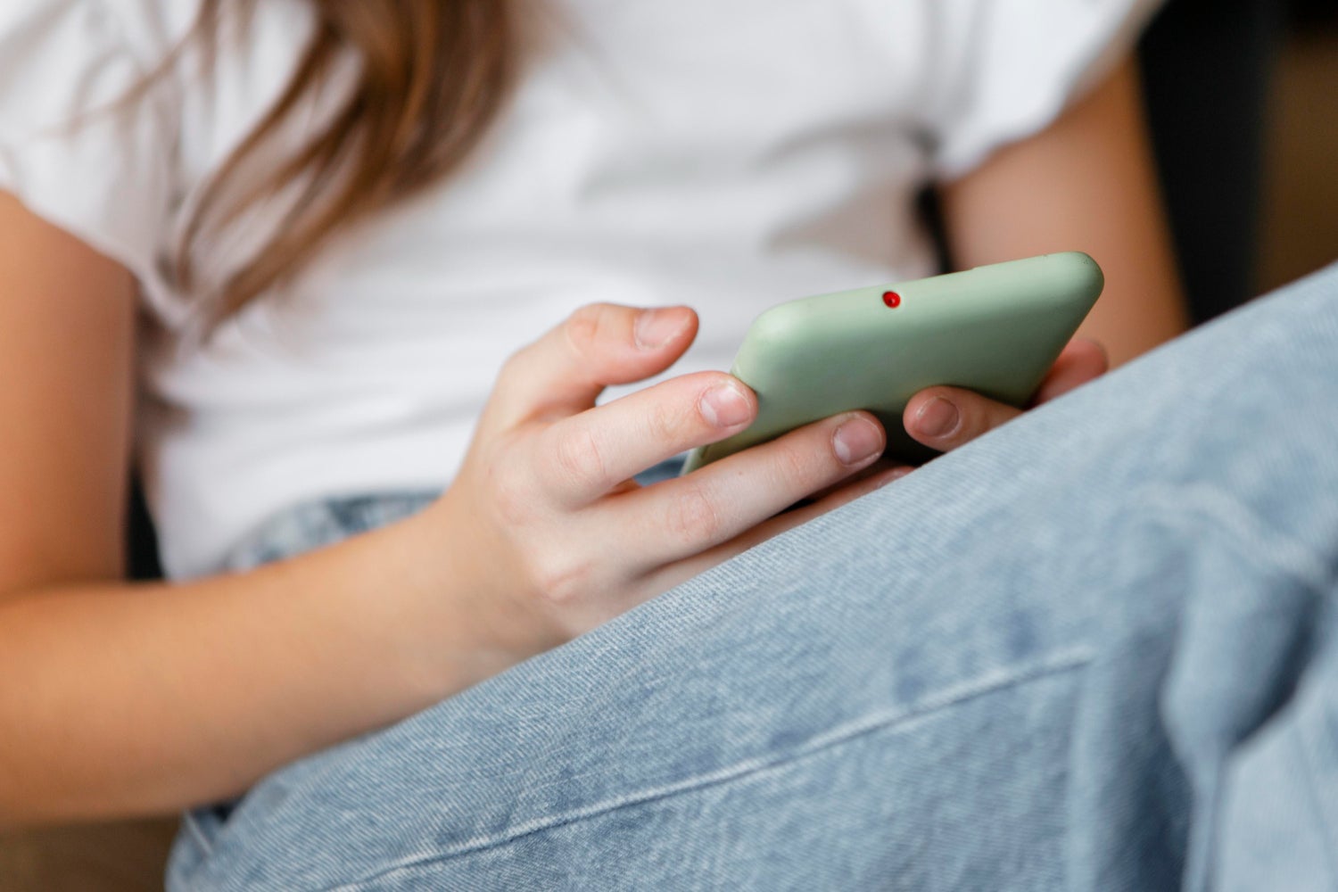 Una adolescente sostiene un teléfono móvil. Una adolescente sostiene un teléfono móvil.