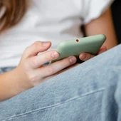 Una adolescente sostiene un teléfono móvil. Una adolescente sostiene un teléfono móvil.