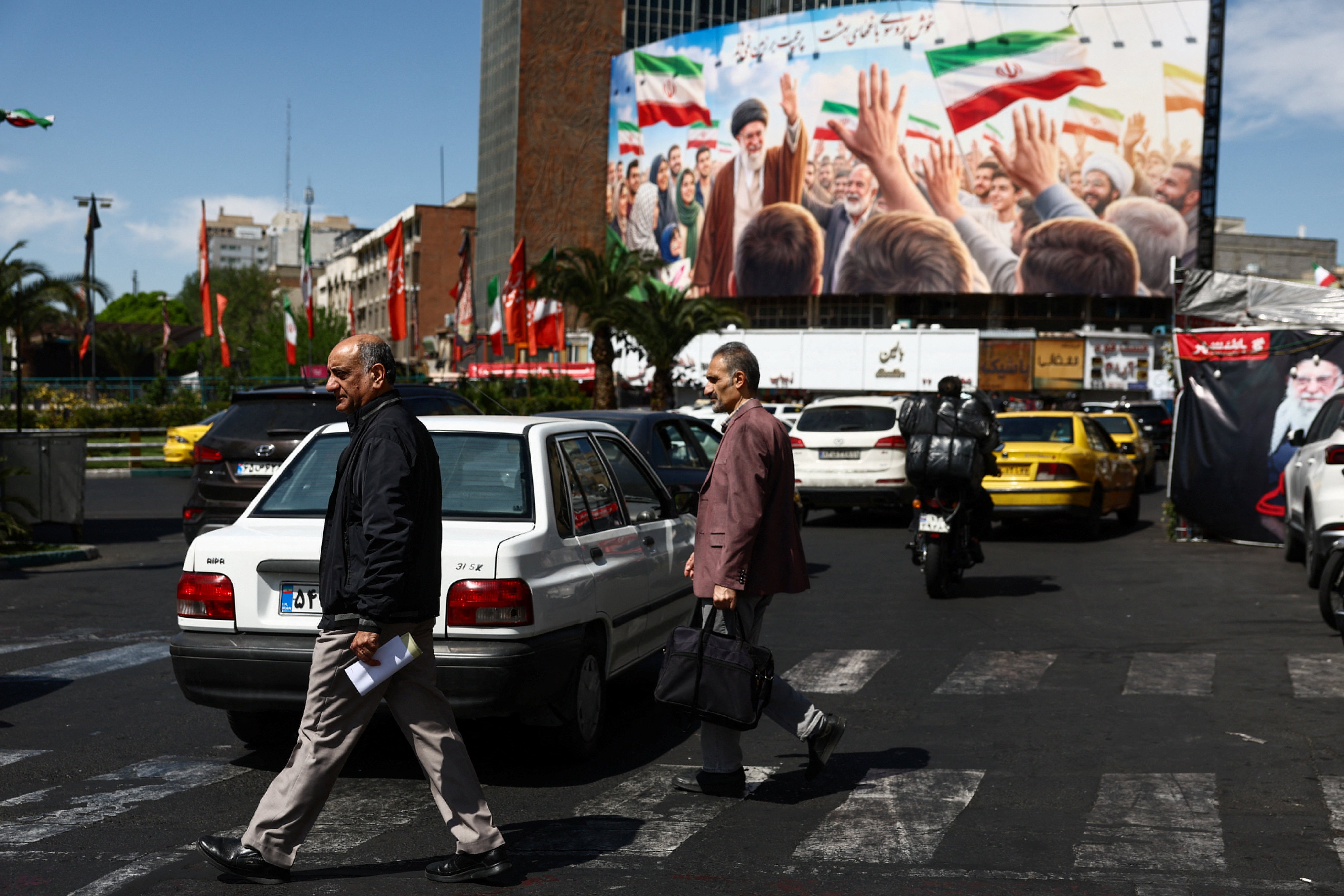 Varias personas pasan junto a una valla publicitaria con la imagen del difunto Líder Supremo de Irán, el ayatolá Ali Khamenei, en un edificio de Teherán. Varias personas pasan junto a una valla publicitaria con la imagen del difunto Líder Supremo de Irán, el ayatolá Ali Khamenei, en un edificio de Teherán.