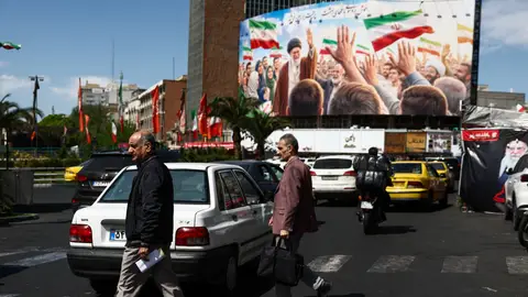 Varias personas pasan junto a una valla publicitaria con la imagen del difunto Líder Supremo de Irán, el ayatolá Ali Khamenei, en un edificio de Teherán. Varias personas pasan junto a una valla publicitaria con la imagen del difunto Líder Supremo de Irán, el ayatolá Ali Khamenei, en un edificio de Teherán./ Majid Asgaripour/WANA/ Reuters