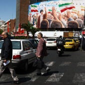  Varias personas pasan junto a una valla publicitaria con la imagen del difunto Líder Supremo de Irán, el ayatolá Ali Khamenei, en un edificio de Teherán./ Majid Asgaripour/WANA/ Reuters