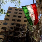 Una bandera iraní ondea cerca de un edificio residencial dañado por un ataque el 4 de marzo en Teherán./ REUTERS/Thaier Al Sudani