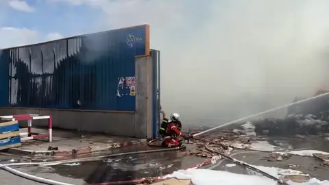 Los bomberos de la Comunidad de Madrid evitan que un fuego originado en el exterior de una nave del polígono Azque se propague a una gasolinera Bombero de la Comunidad de Madrid atacando un fuego