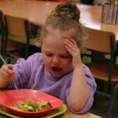 Una niña llora porque no le gusta el brócoli