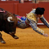 El diestro Morante de la Puebla sufre una cogida durante la novena corrida de la Feria de Abril de Sevilla/ EFE/ Julio Muñoz