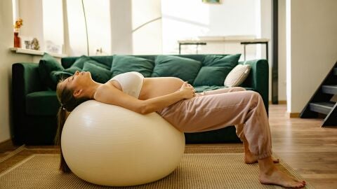 Una mujer embarazada entrena el suelo p&eacute;lvico con una pelota de gimnasia