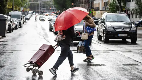 Dos personas caminan bajo la lluvia en Madrid Dos personas caminan bajo la lluvia en Madrid