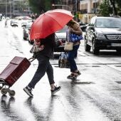 Dos personas caminan bajo la lluvia en Madrid