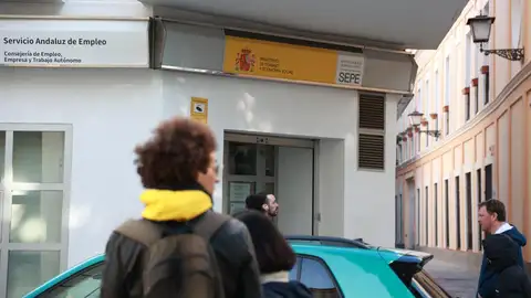 La provincia de Sevilla supera los 850.000 afiliados a la Seguridad Social por primera vez en su historia Varias personas transitan frente a la oficina de Empleo próxima a la Plaza del Museo, en foto de archivo.